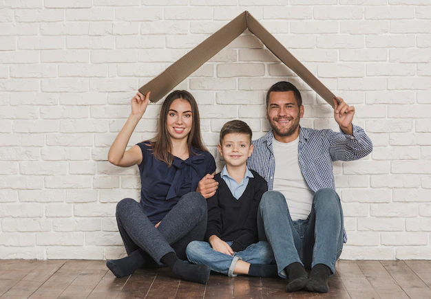 Imagen de una familia feliz frente a su casa construida con crédito FOVISSSTE